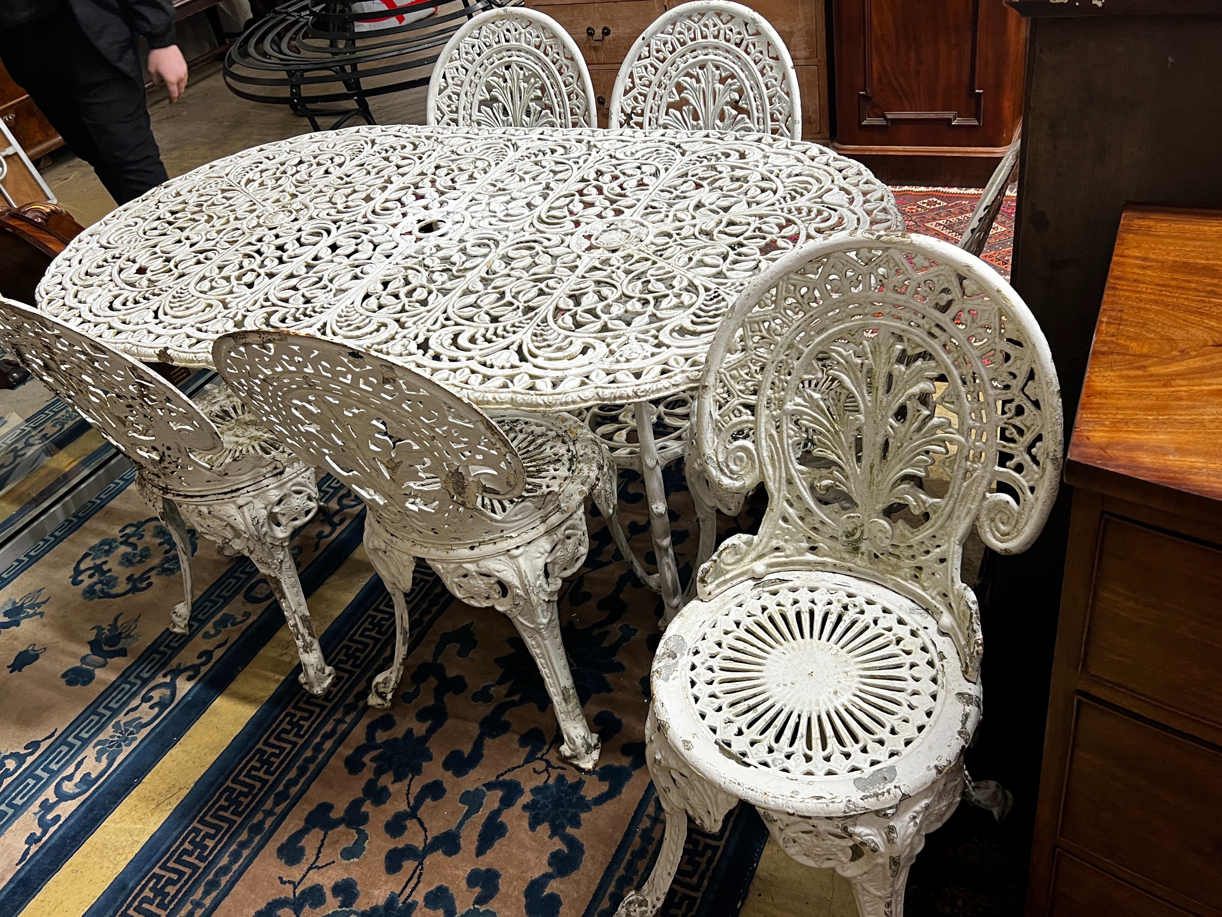 A Victorian style cast aluminium garden table, width 160cm, depth 90cm, height 67cm and six cast iron garden chairs